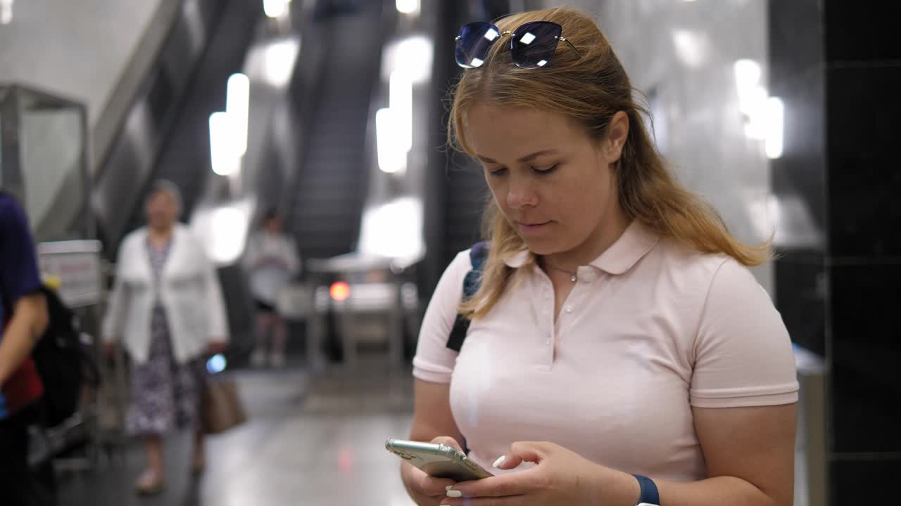 一个女人在地铁站拿着手机的手特写。视频下载