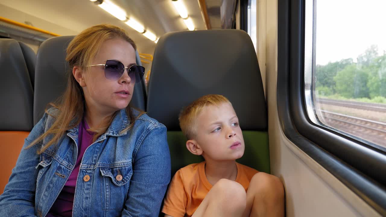 火车上的母子，他们坐在椅子上望着窗外视频下载