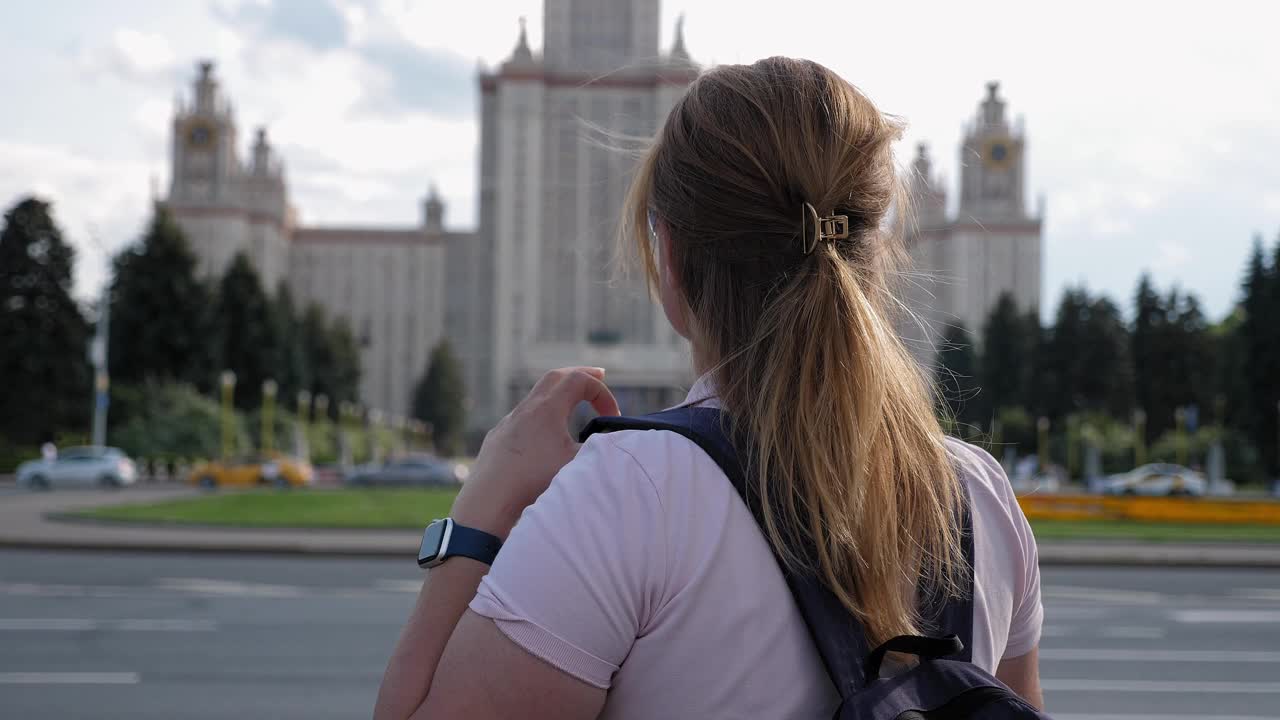 一个背着双肩包的女学生站在那里看着州立大学。视频下载