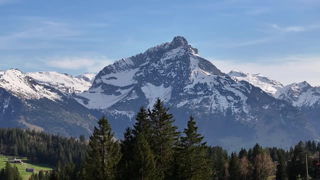 瑞士阿尔卑斯山高耸的雪山山脊。在背景中，阿姆登村附近的滑雪和旅游中心视频素材