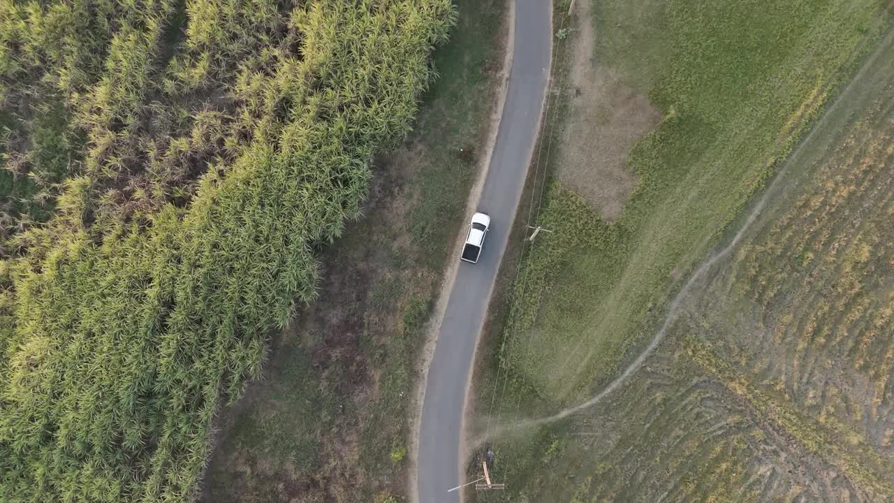 无人机拍摄鸟瞰风景，驾驶皮卡车在旱季偏僻的乡村道路上行驶视频素材