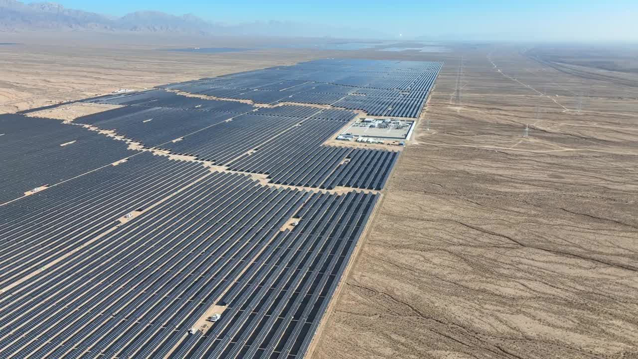 在干旱的沙漠地区飞过巨大的可再生能源太阳能农场——缓慢下降的空中特写视频素材