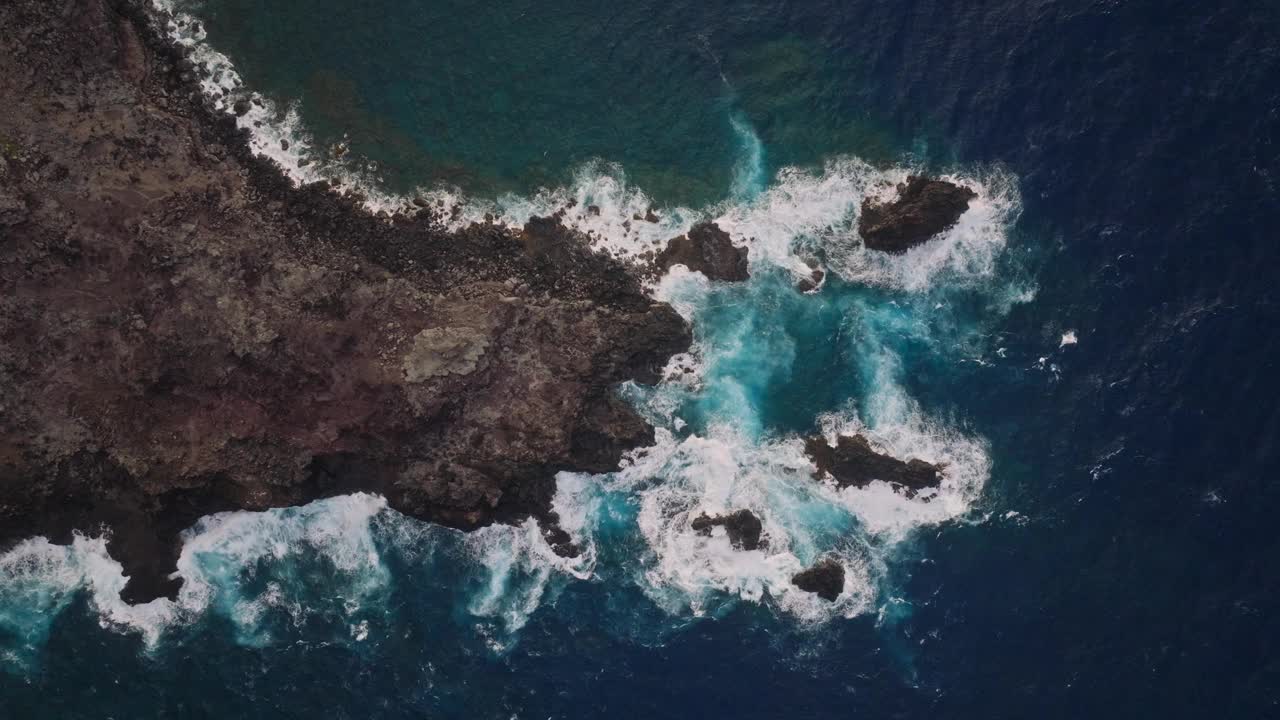 从空中俯瞰，深蓝色的海水冲刷着被侵蚀的悬崖视频素材