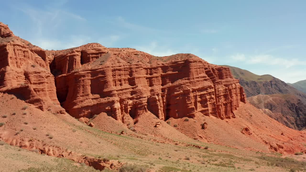 徒步穿越康内克的红色峡谷。穿越吉尔吉斯斯坦山脉的旅行。易受侵蚀的干燥的红色沙质岩层视频下载