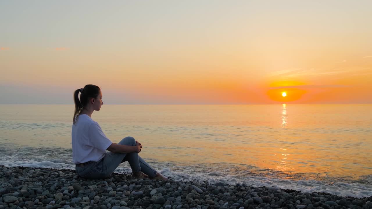 女人在海边看日落——慢镜头视频素材