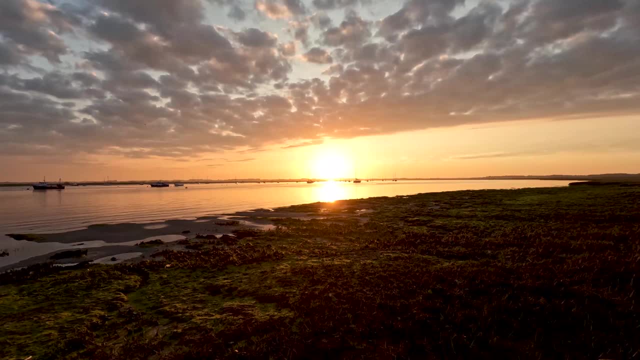 英国萨福克郡鲍德西海滩德本河上壮观的日落的4k延时摄影视频下载