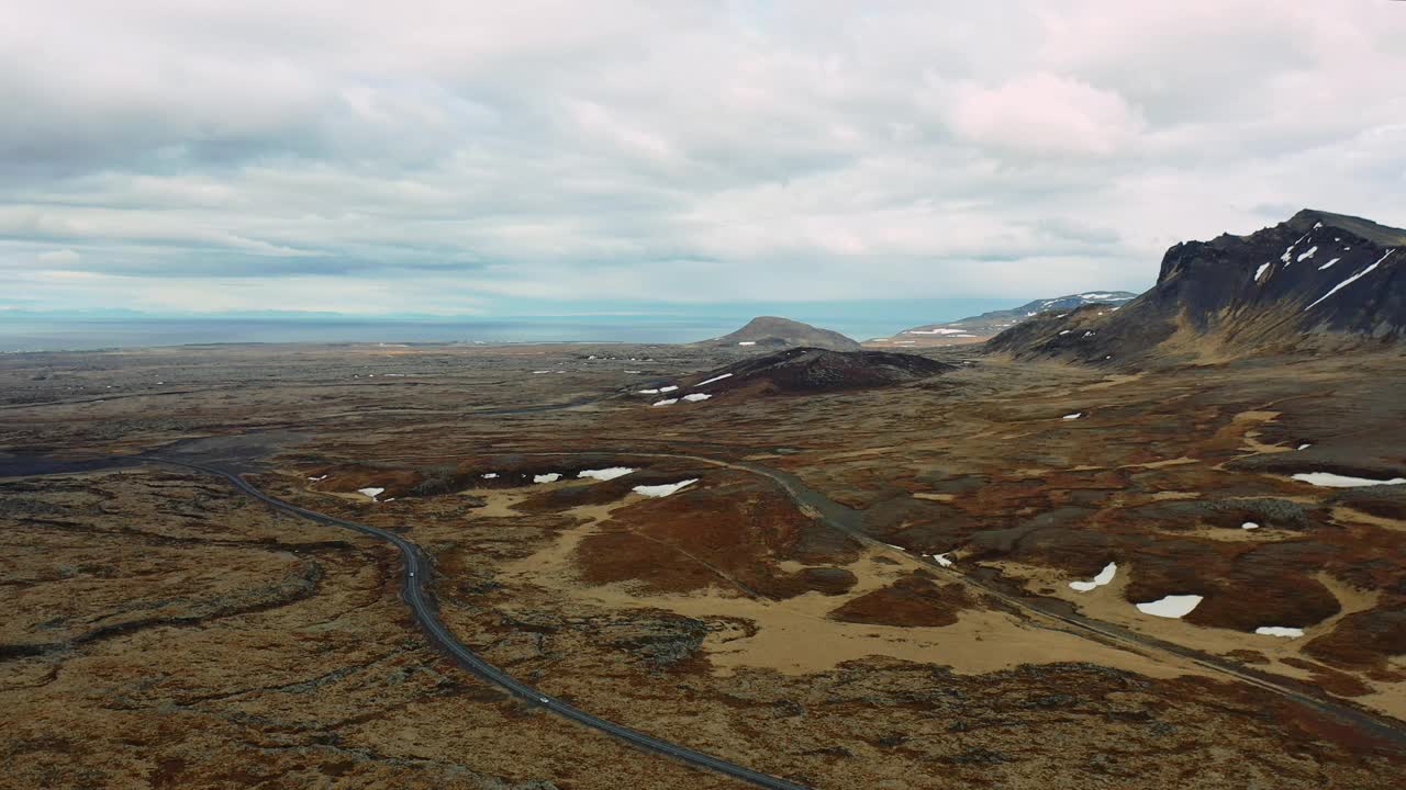 俯瞰白色汽车行驶在斯奈费尔斯半岛广阔的火山地带视频素材