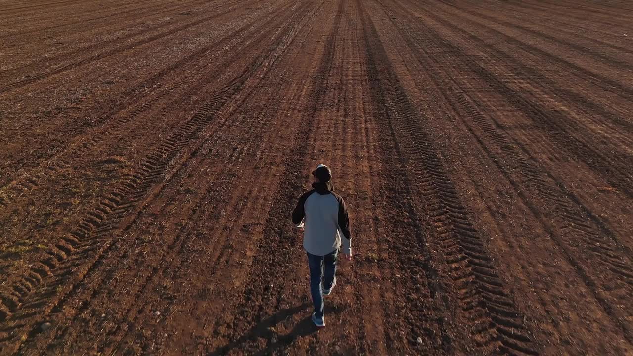 一个人独自走在一片泥泞的田野中间视频下载