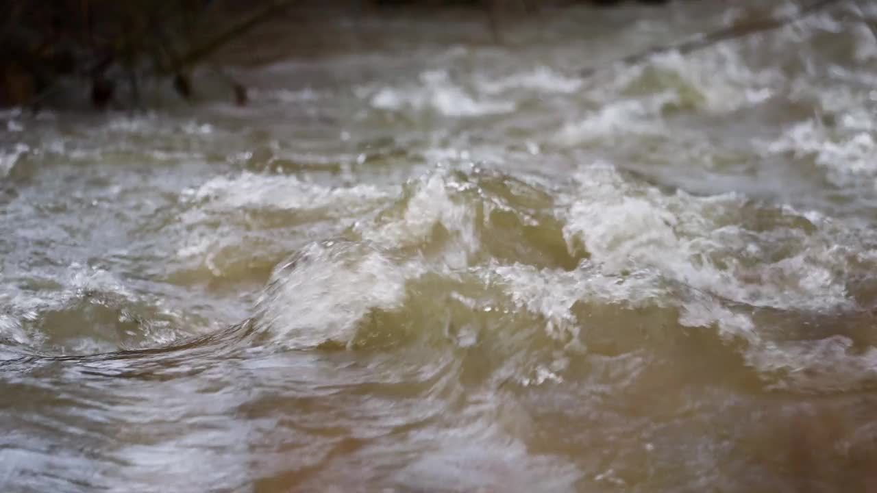 满溢着肮脏的棕色雨水的小溪视频素材