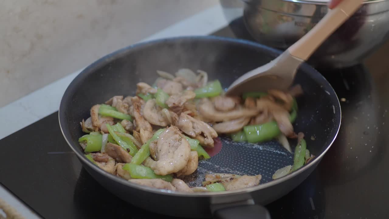 用平底锅炒鸡肉和蔬菜需要在炉子上炒食材视频素材