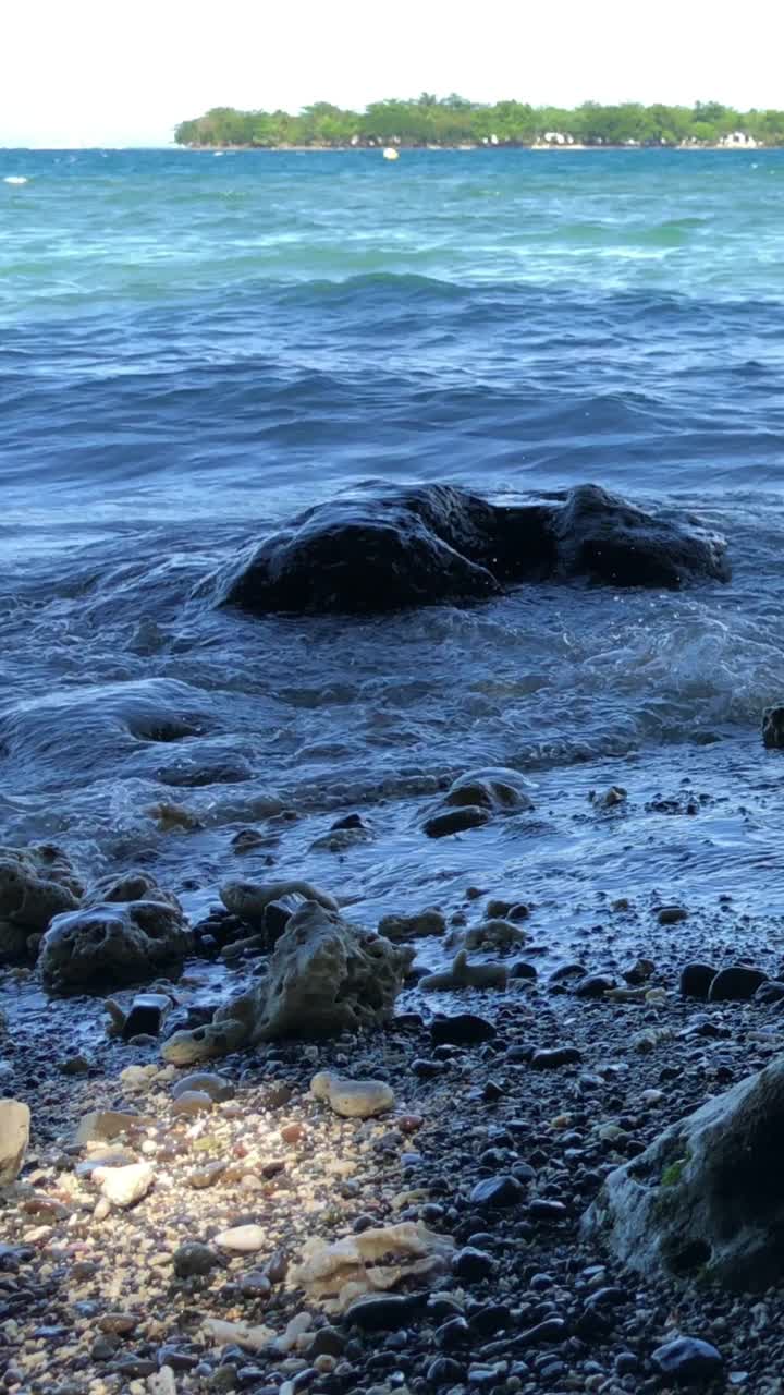 在菲律宾南部的热带海滩上，海浪轻轻地翻滚到岸边。视频素材