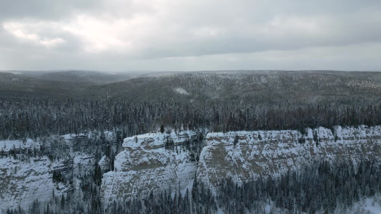 山崖河川鸟瞰图。夹。霜冻的寒雪的早晨和一望无际的常绿松林。视频素材