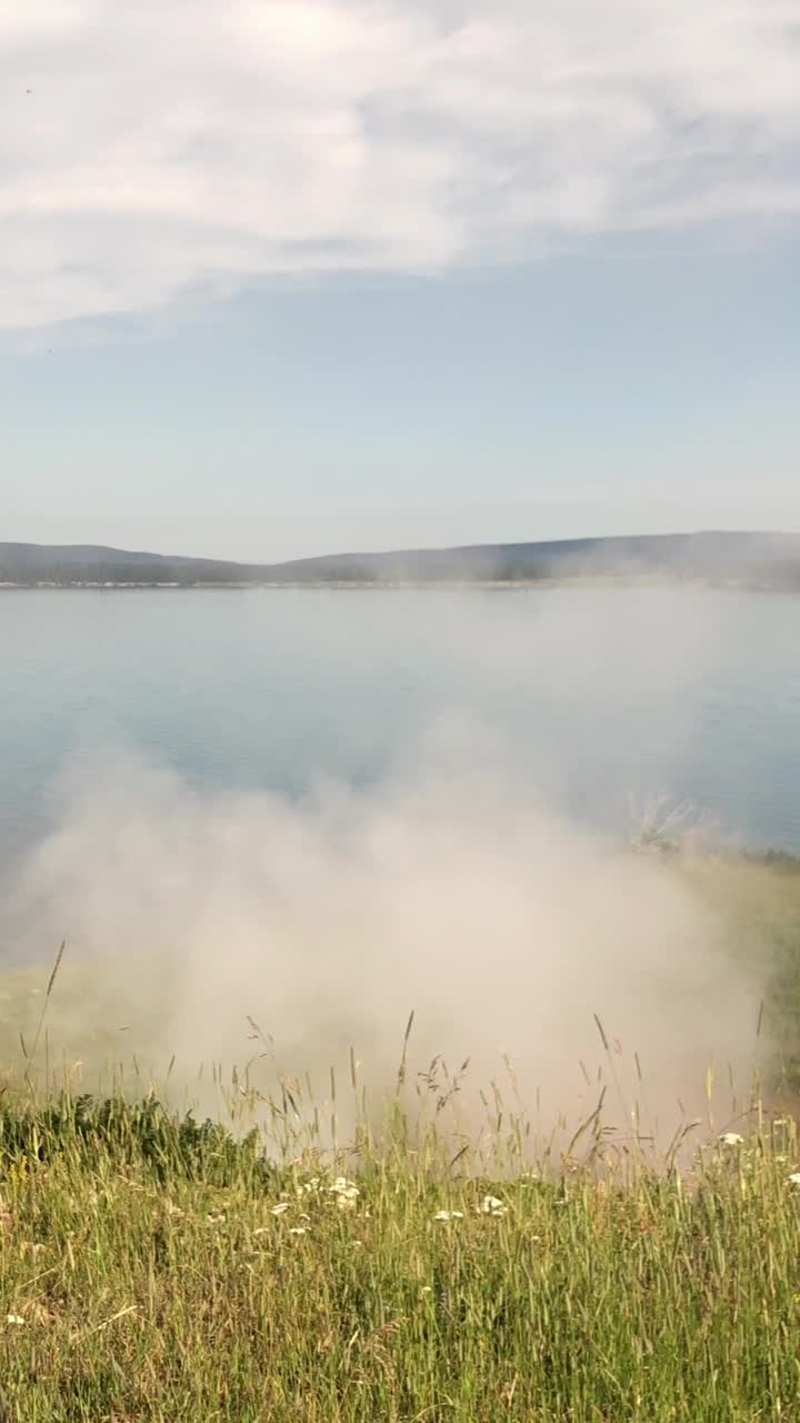 沿着黄石国家公园的黄石湖俯瞰，蒸汽船点的蒸汽喷口缓缓升起的烟雾稳定的镜头。视频下载