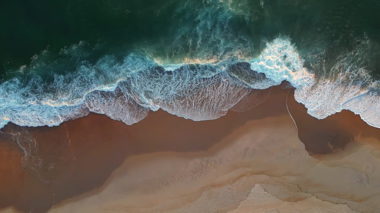 强大的海浪在沙滩上。从空中俯瞰海滩上的海浪视频素材