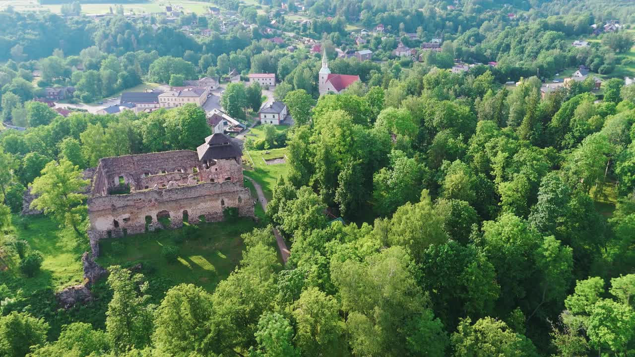 拉脱维亚劳纳市鸟瞰图。拉脱维亚小镇劳纳的全景。中世纪城堡遗址和劳那福音路德教会4K航拍视频素材