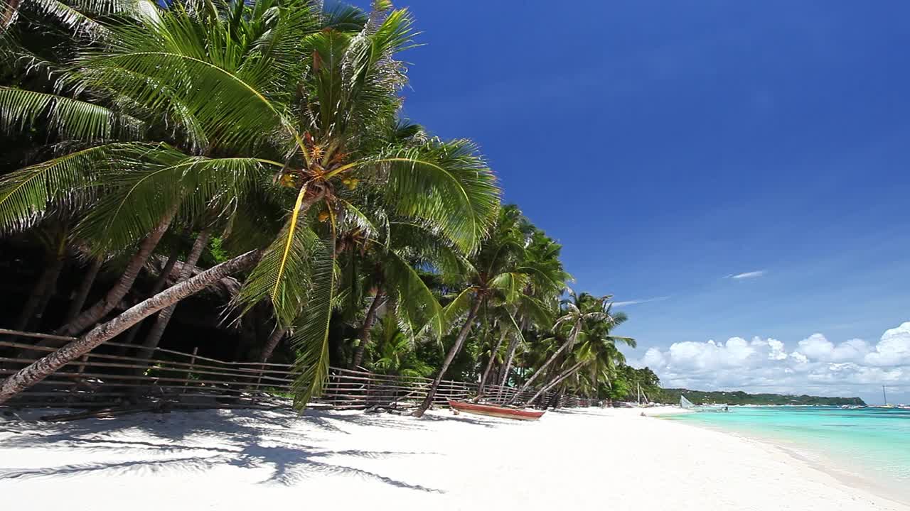 原始的海滩上有棕榈树，白色的沙滩和绿松石般的热带海洋。旅游目的地视频素材