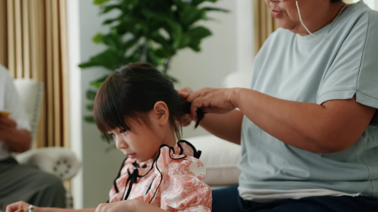 小孙女坐着和爷爷奶奶下棋。视频素材