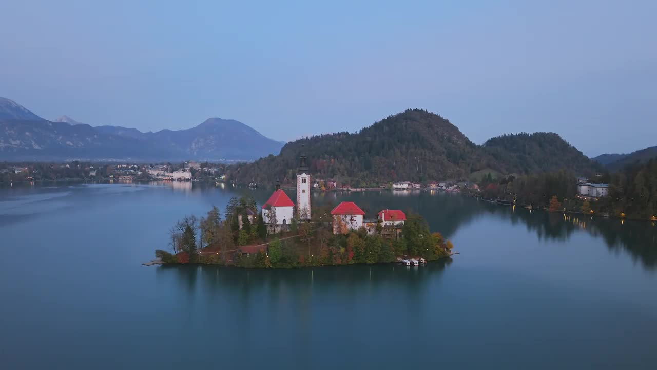 夜间，斯洛文尼亚布莱德岛(Blejski otok)上的圣母升天朝圣教堂和布莱德湖上的布莱德城堡视频下载