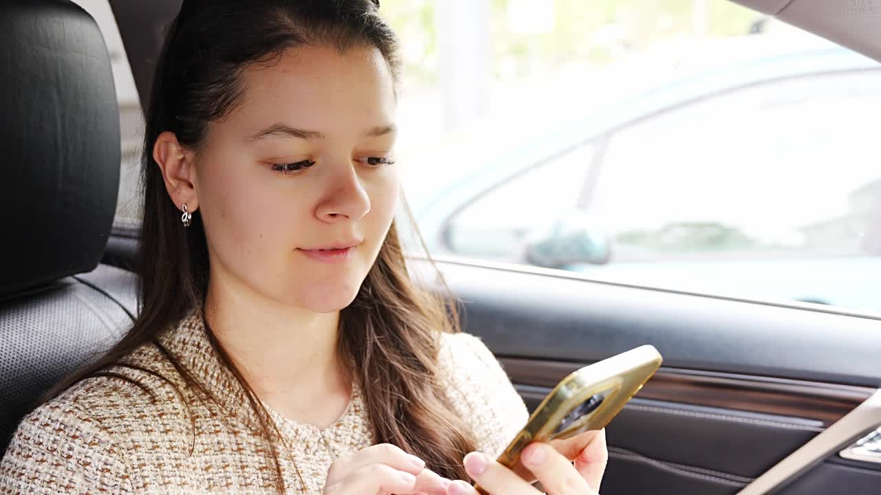 年轻女子在车内用手机听语音信息视频素材