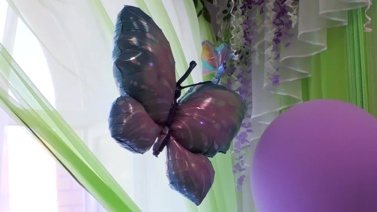 一个可充气的蝴蝶和一个靠窗的氦气球。视频素材