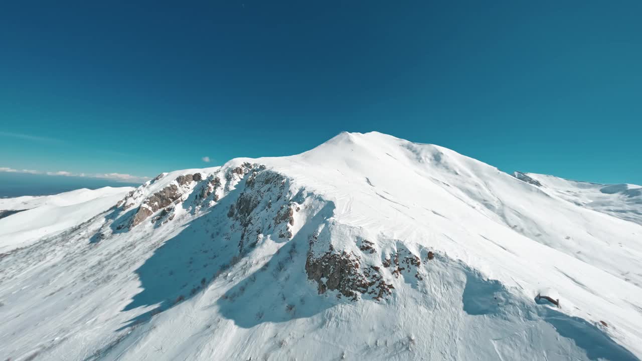 白雪皑皑的山峰下碧蓝的天空，鸟瞰视频素材