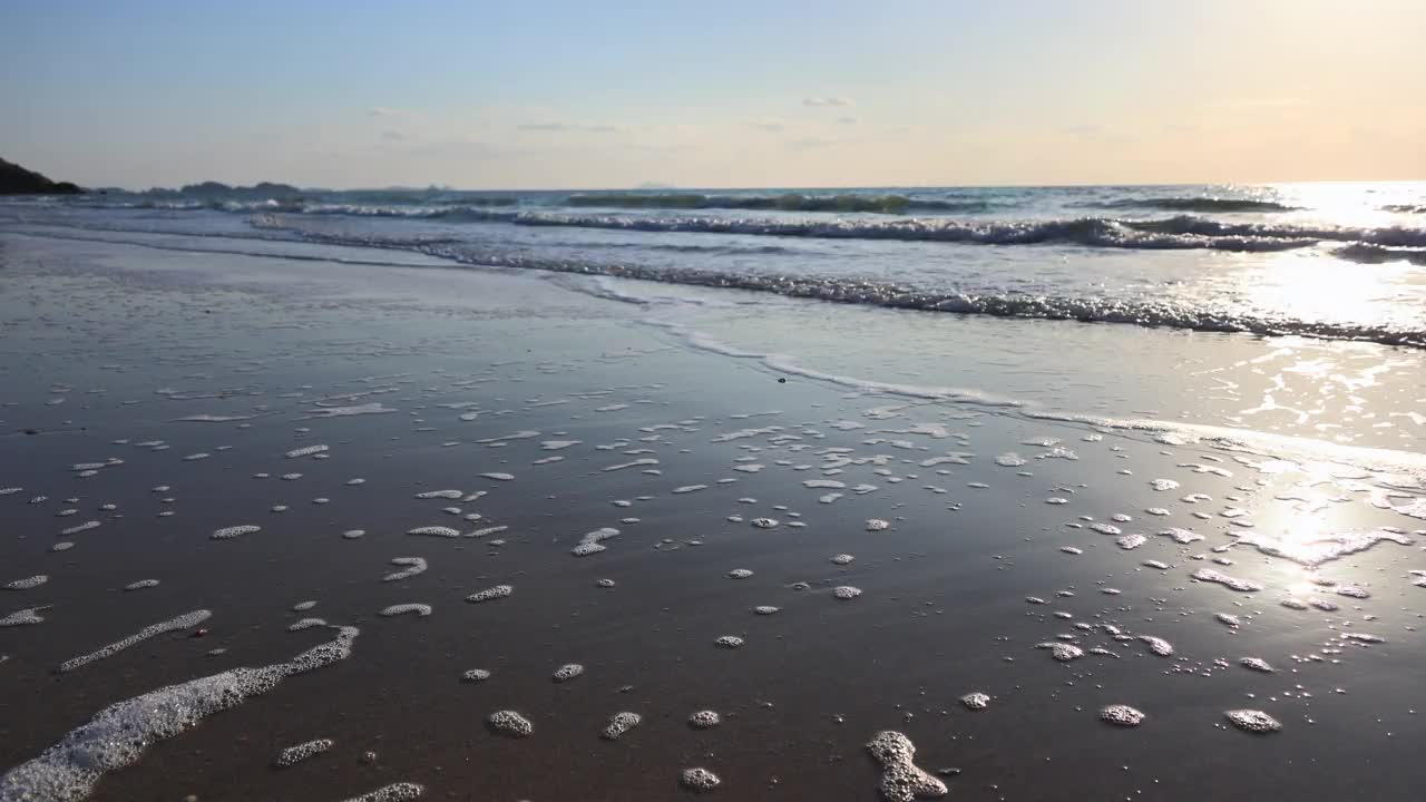 傍晚时分，柔和的海浪涌向海滩。视频素材