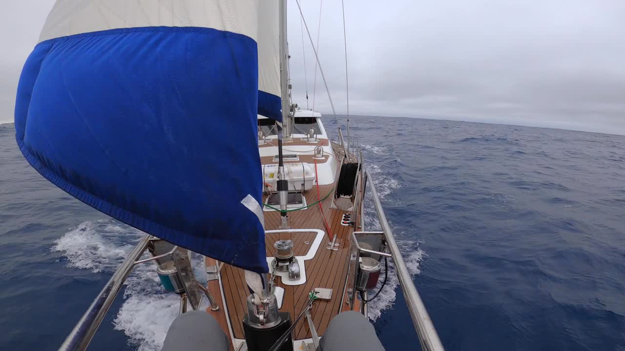一艘帆船在海上航行，帆上挂着蓝白色的旗帜视频下载