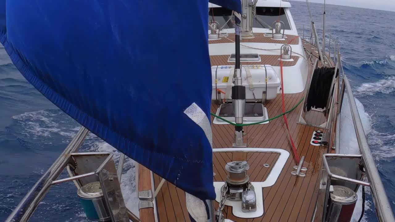 一艘蓝色帆的帆船在公海上的航拍视频下载