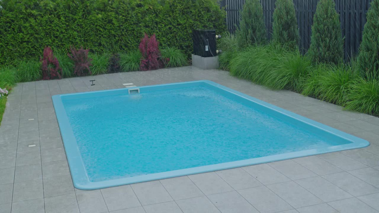 大雨落在带游泳池的房子后院。视频下载