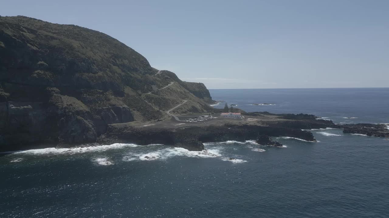 在一个阳光明媚的日子里，海浪冲击着岩石海岸，鸟瞰图视频素材