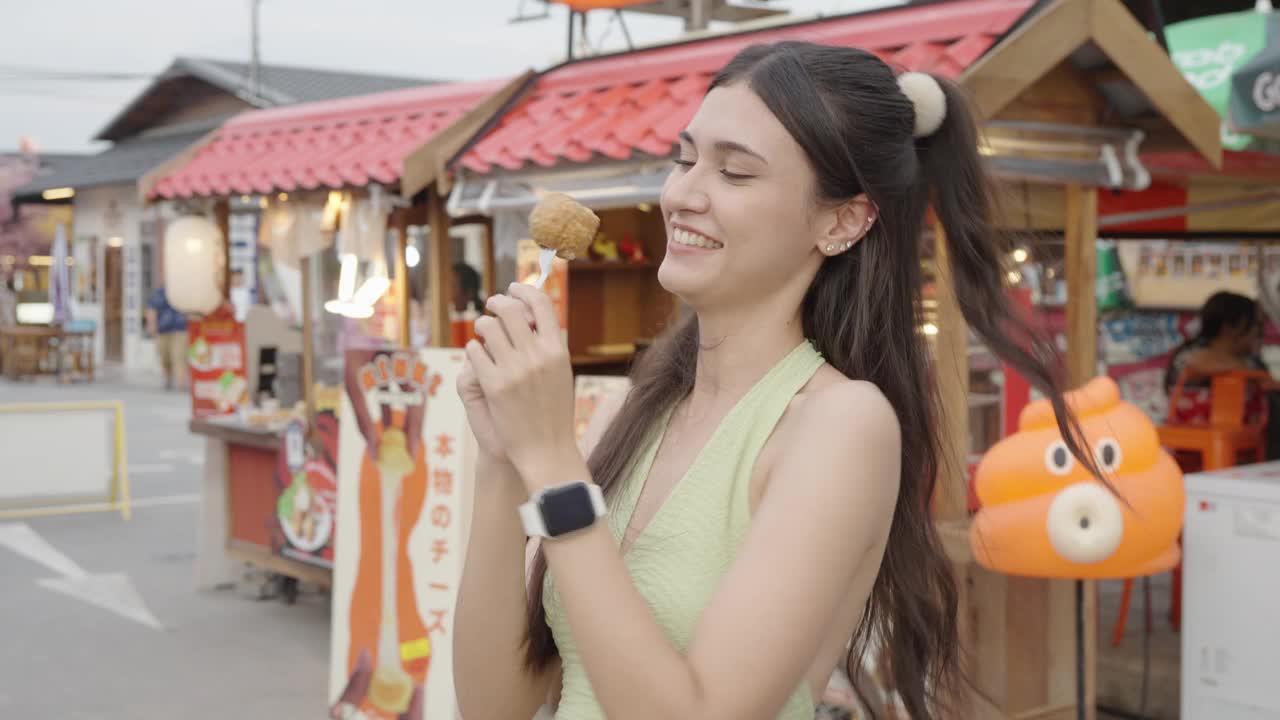 快乐的年轻旅游亚洲妇女享受和乐趣的传统亚洲街头小吃在曼谷。视频素材