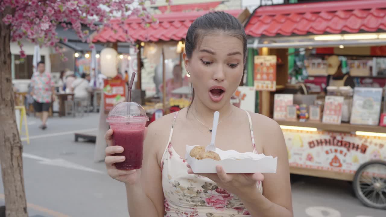 快乐的年轻旅游亚洲妇女享受和乐趣的传统亚洲街头小吃在曼谷。视频素材