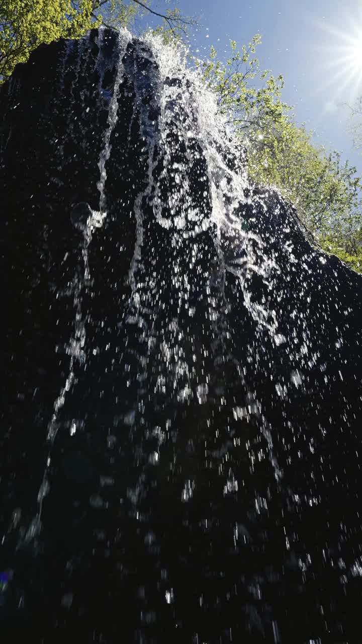 瀑布流在洞穴和茂密的森林电影视图，静态视图视频素材