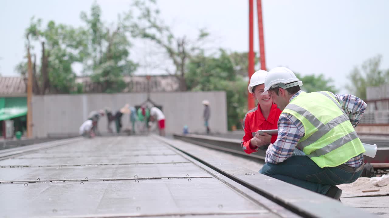 建筑承包商和女工程师穿着安全装备，讨论生产计划，混凝土墙设计，检查建筑预制墙工厂的水泥块质量。生产。建设产业。视频下载