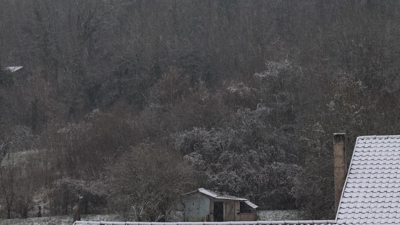 雪下的乡村风景。白雪覆盖的花园木屋。农村下雪了。农村的冬天。屋顶被雪覆盖着。一个村庄的降雪视频下载