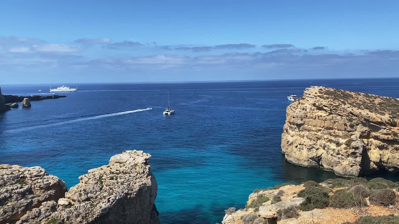 美丽的科米诺海洞和天然拱门。船在清澈的地中海。从圣玛丽亚塔附近的悬崖上看视频素材