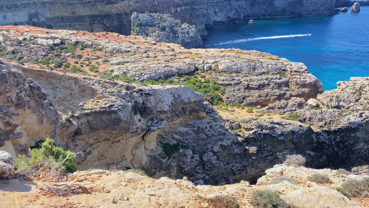 美丽的科米诺海洞和天然拱门。船在清澈的地中海。从圣玛丽亚塔附近的悬崖上看视频素材