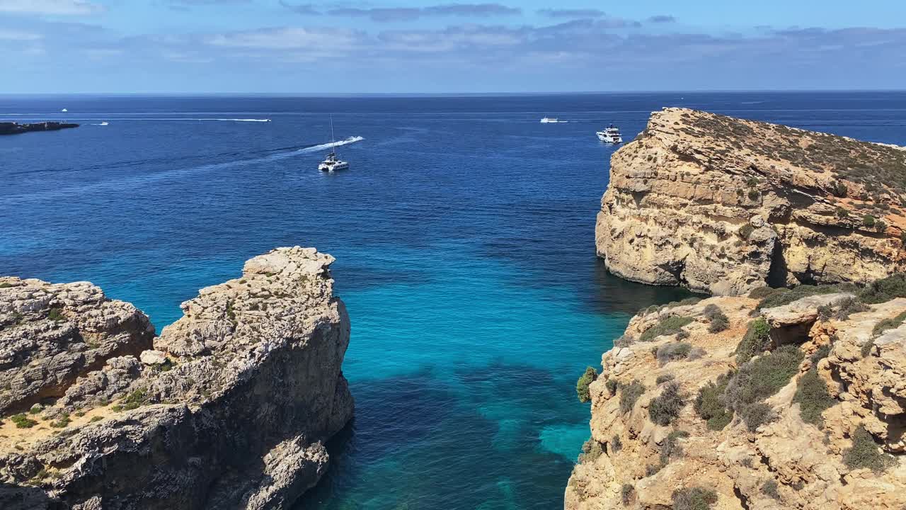 美丽的科米诺海洞和天然拱门。船在清澈的地中海。从圣玛丽亚塔附近的悬崖上看视频素材