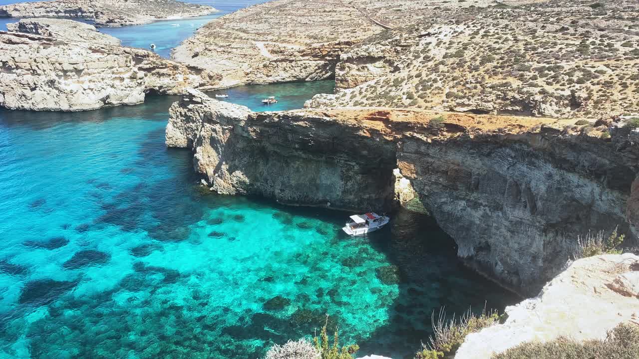 美丽的科米诺海洞和天然拱门。船在清澈的地中海。从圣玛丽亚塔附近的悬崖上看视频素材