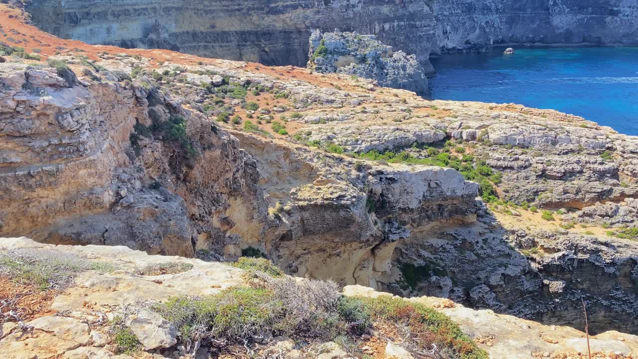 美丽的科米诺海洞和天然拱门。船在清澈的地中海。从圣玛丽亚塔附近的悬崖上看视频素材