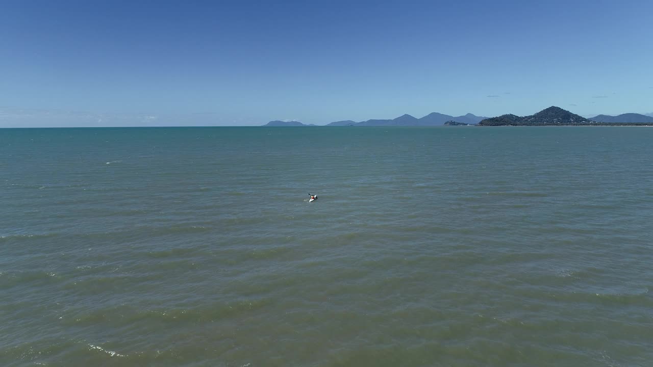 皮艇独木舟平静的水域和遥远的山脉在棕榈湾海滩视频素材