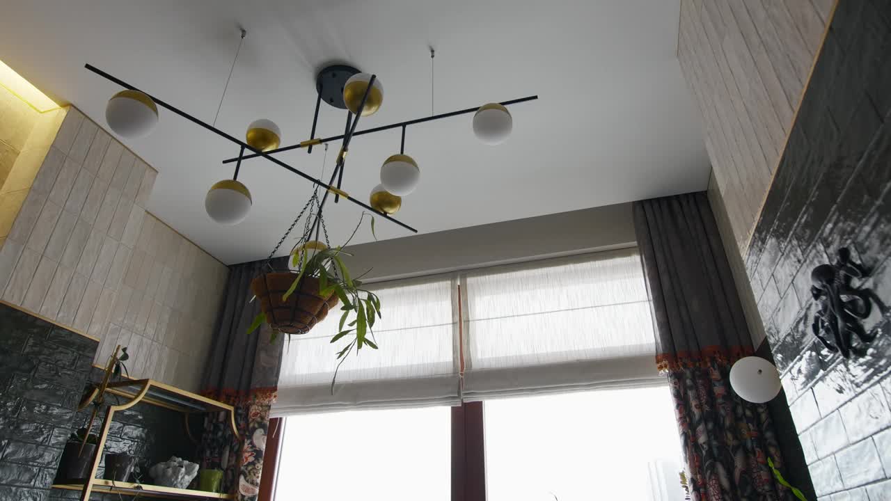低角度的时尚现代吊灯与悬挂植物。有创造力。小房间的细节与深色和米色的墙壁形成对比视频下载