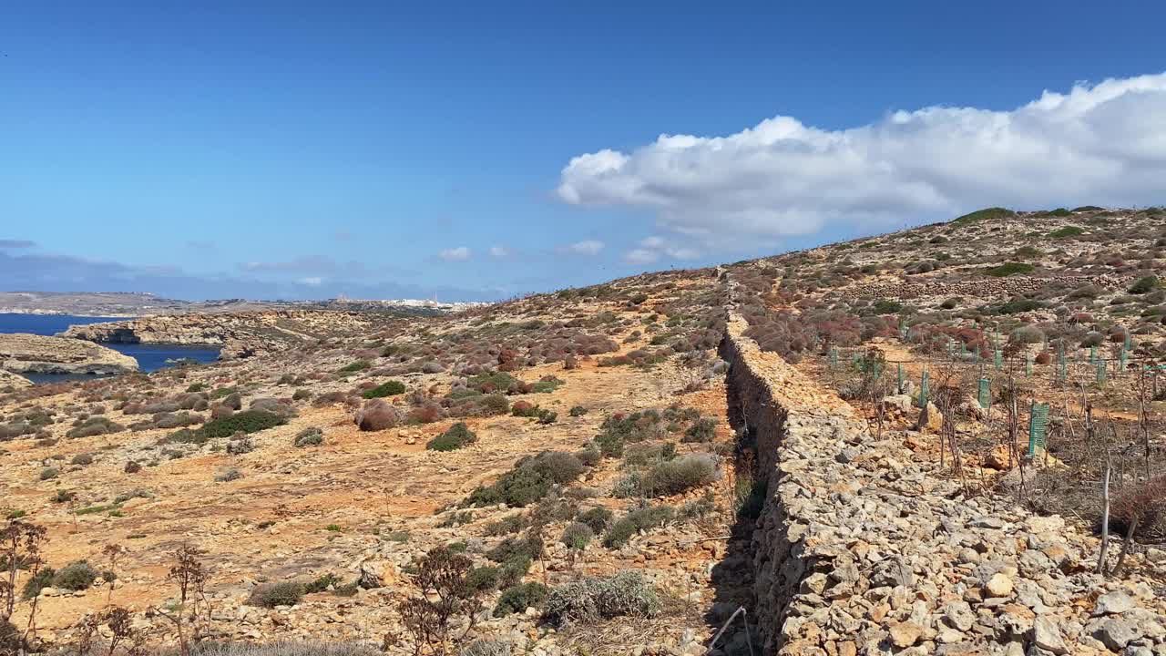 美丽的科米诺海洞和天然拱门。船在清澈的地中海。从圣玛丽亚塔附近的悬崖上看视频素材