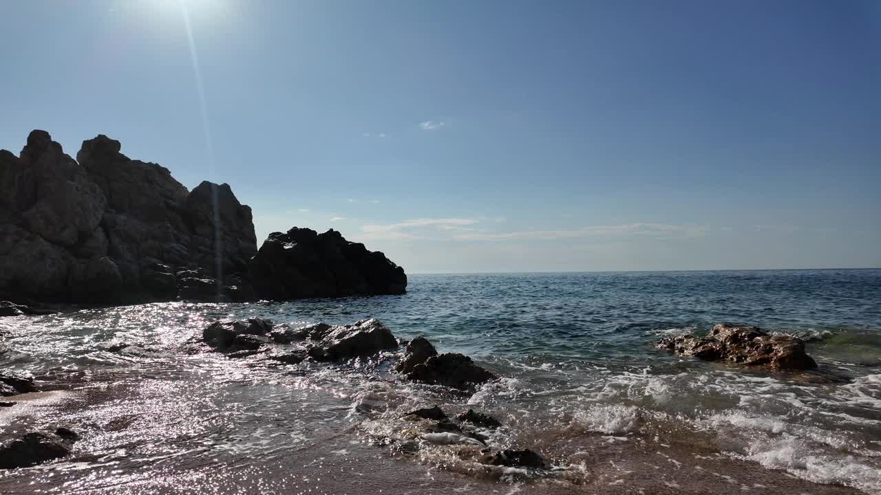 西班牙空旷的岩石海滩上美丽的海景，蓝天，背景，4K视频下载