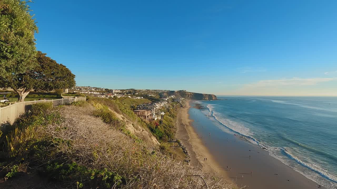 沿海海滩有一个令人惊叹的日落景色，从悬崖上看，下面是波光粼粼的海洋视频素材