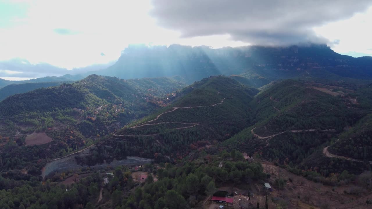 多山的风景，蜿蜒的道路和阳光穿透云层视频素材