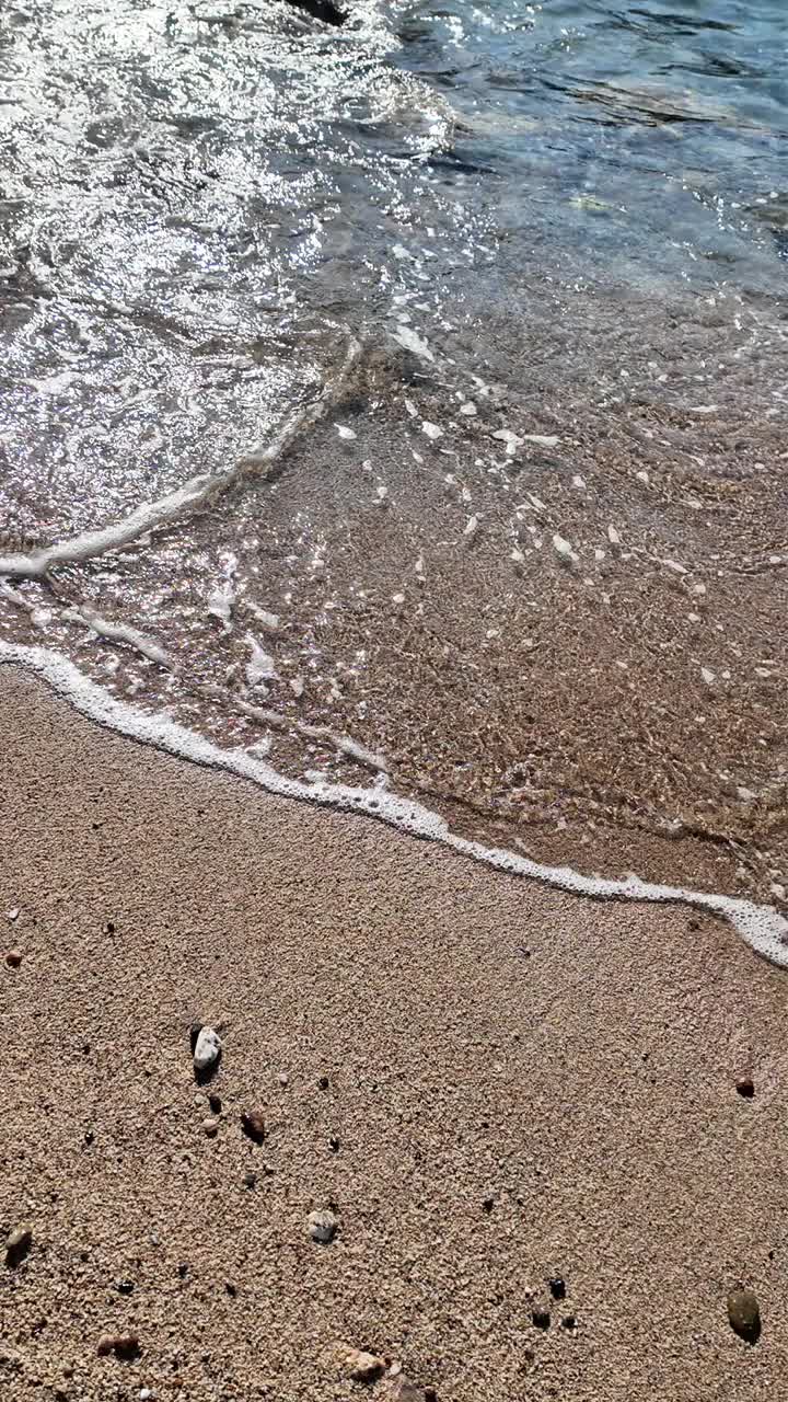 海景的波浪，泡沫和沙子，垂直的背景视频下载