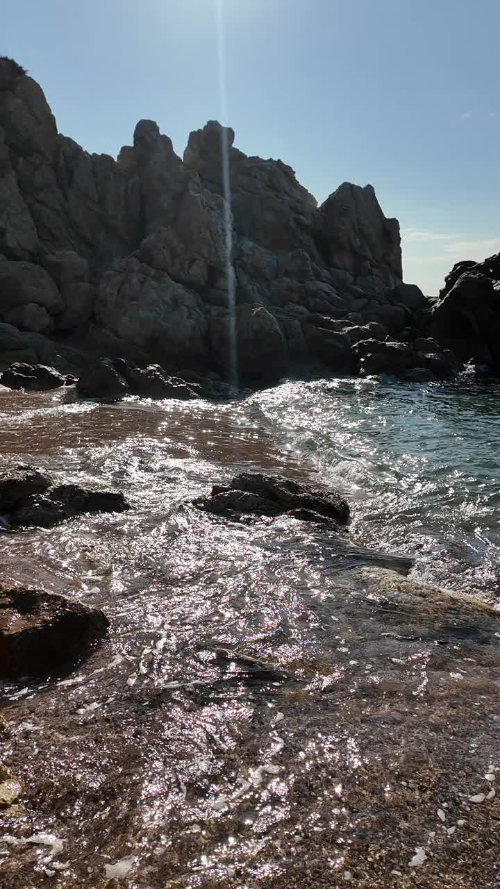 美丽的海景在一个空旷的岩石海滩与蓝天在西班牙，垂直背景视频素材