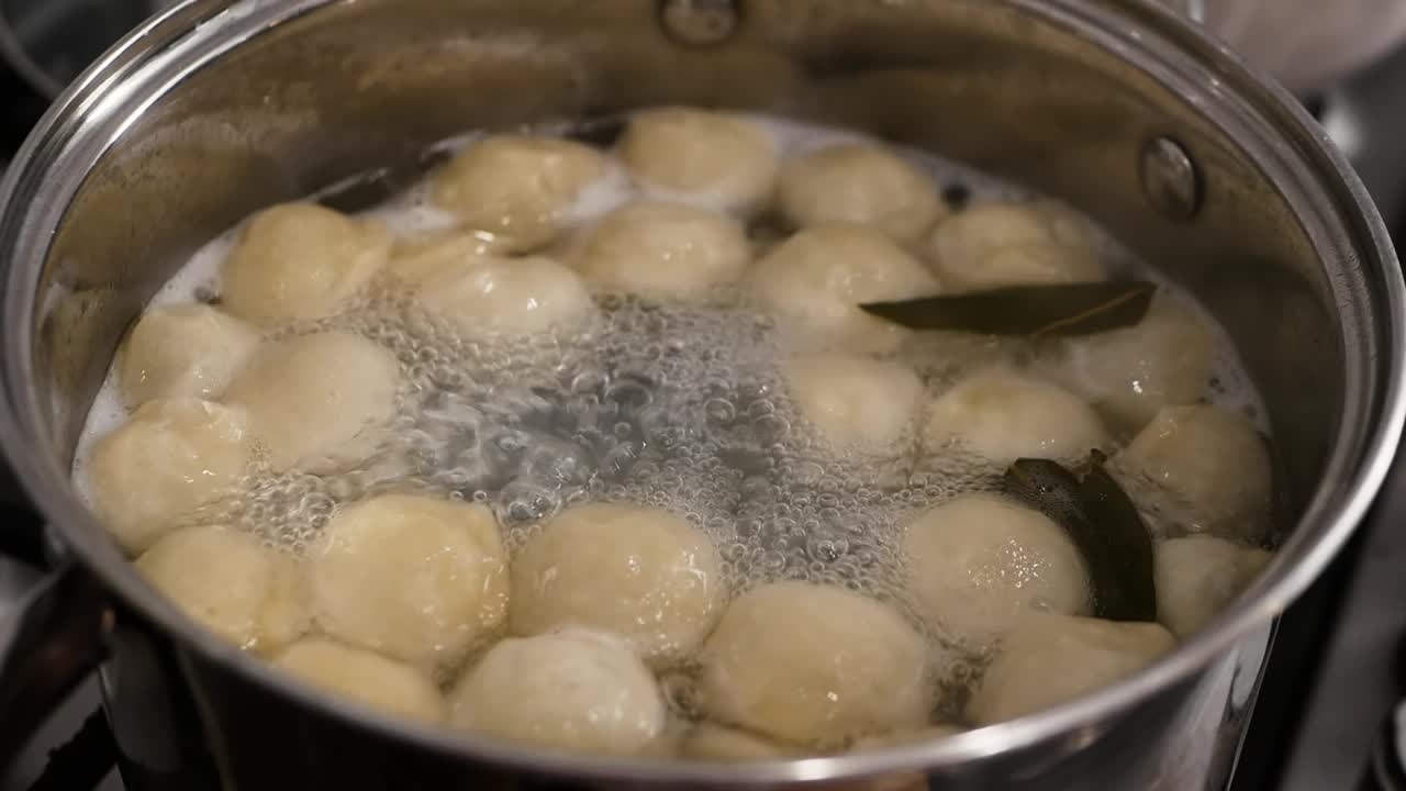 饺子是在平底锅里煮的。在锅里煮饺子。在厨房里用慢动作烹饪食物。视频素材