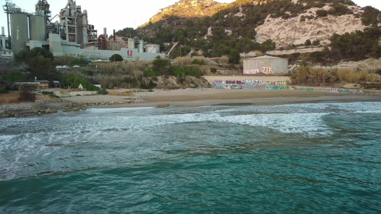 科斯塔加拉夫海滩与海浪，涂鸦，和工厂在背景，鸟瞰图视频素材